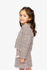 Child wearing the pink and black Deux par Deux cropped jacket with a skirt, side view