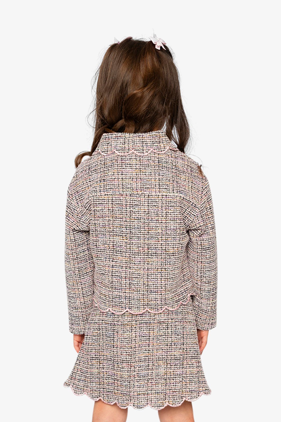 Child wearing the pink and black Deux par Deux cropped jacket with a skirt, back view
