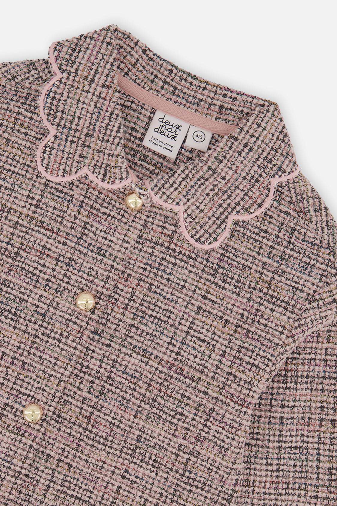 Close-up of the pink scalloped collar and round buttons on the pink and black Deux par Deux jacket
