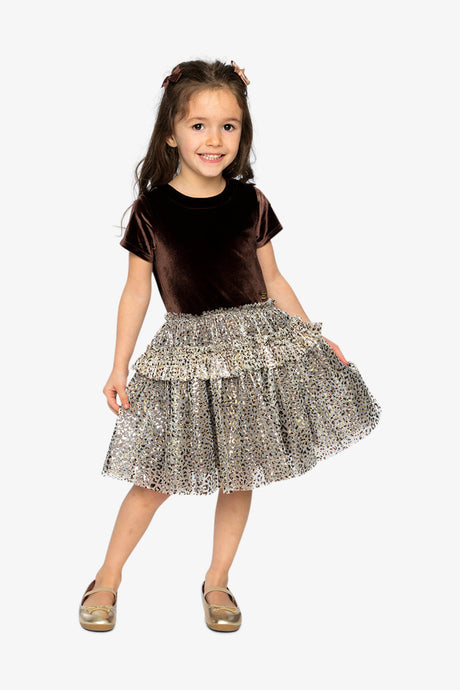 Child wearing the Deux par Deux brown velvet dress with a leopard print mesh skirt and gold flats