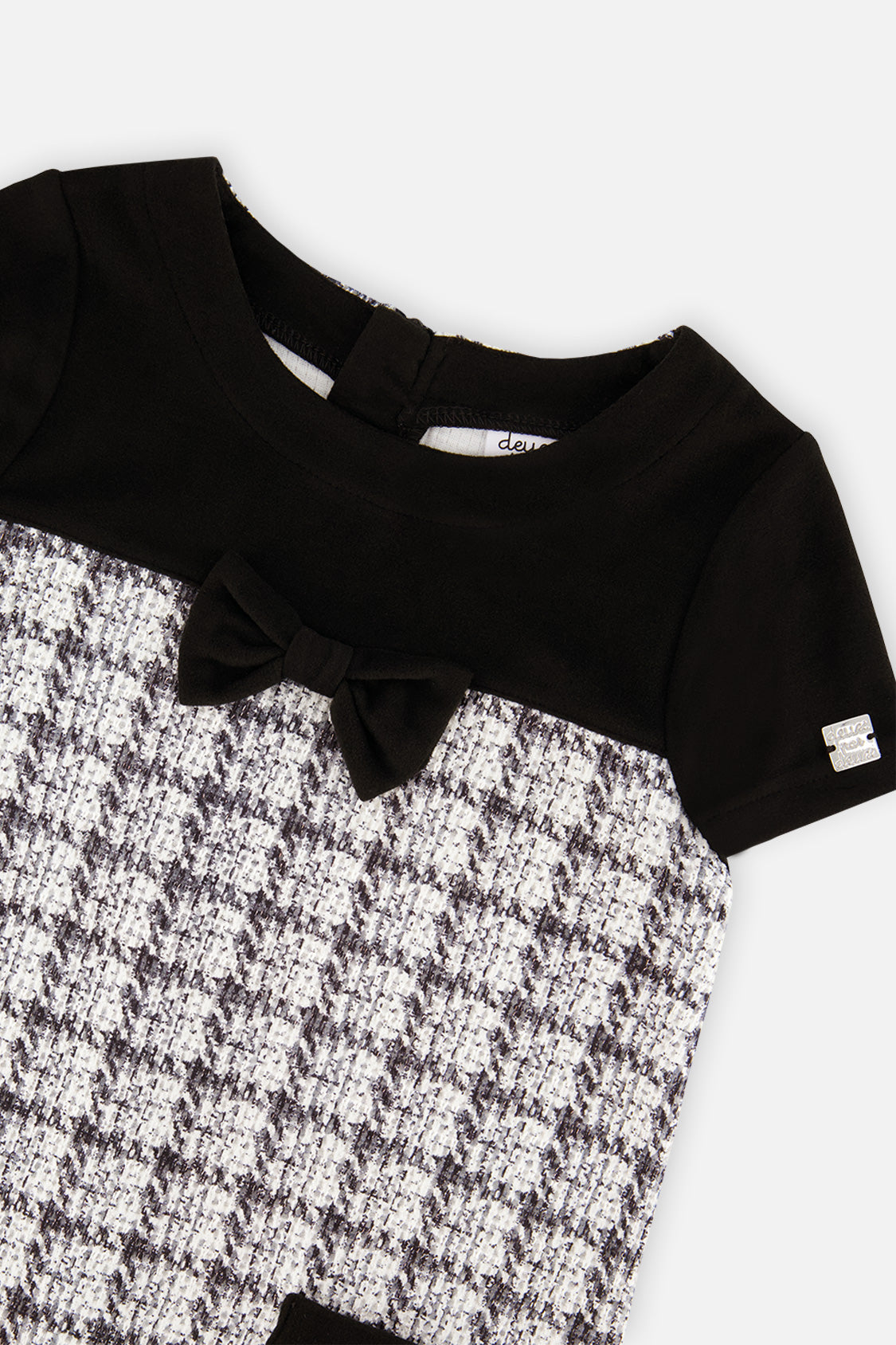 Close-up of the black bow and plaid knit on the front of the dress