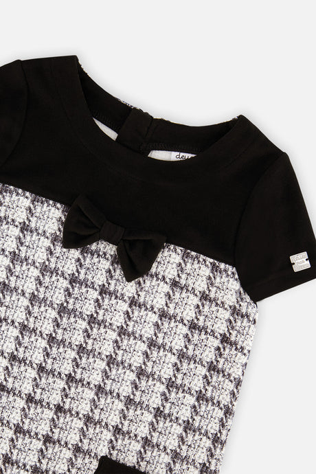 Close-up of the black bow and plaid knit on the front of the dress