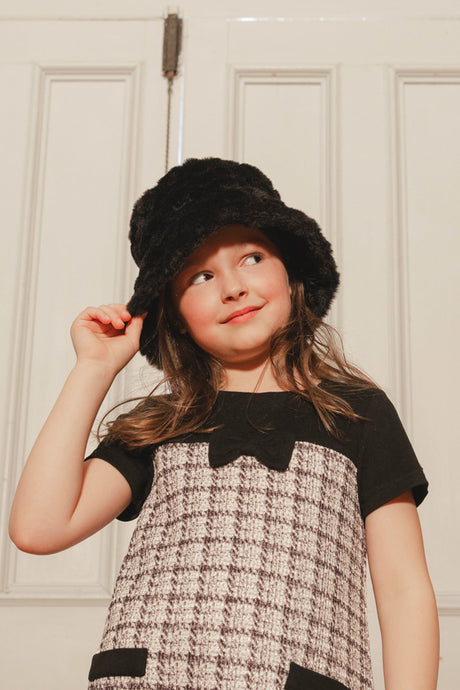 Child wearing the black Deux par Deux faux fur bucket hat with a tweed dress
