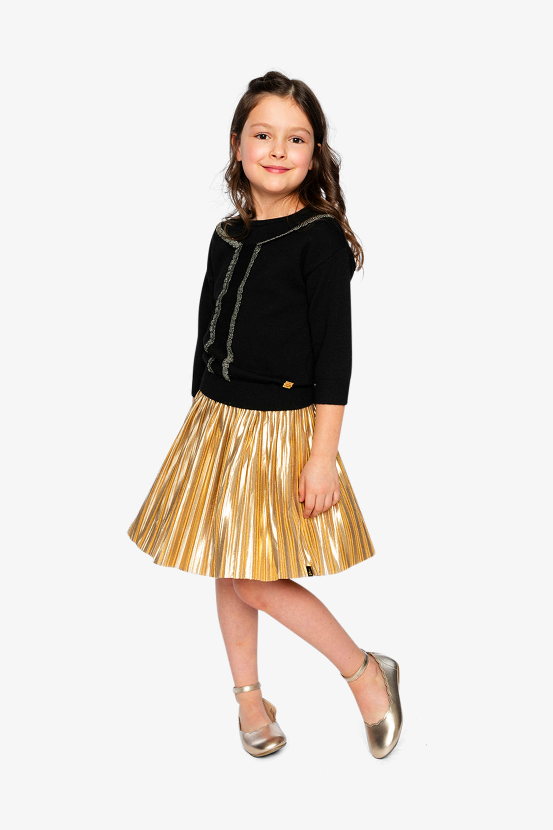 Full-length view of a child in the Deux par Deux black and gold knit sweater