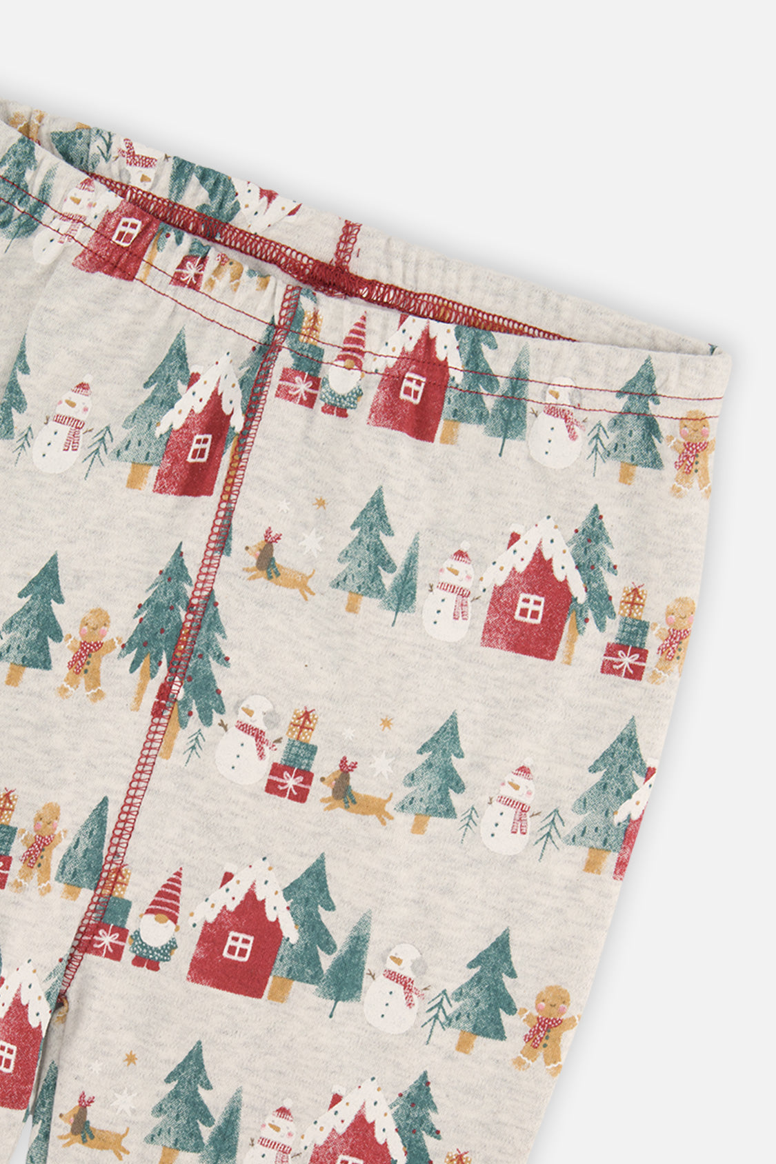 Close-up of the pants waist covered in red houses and pine trees and snowmen and gingerbread figures