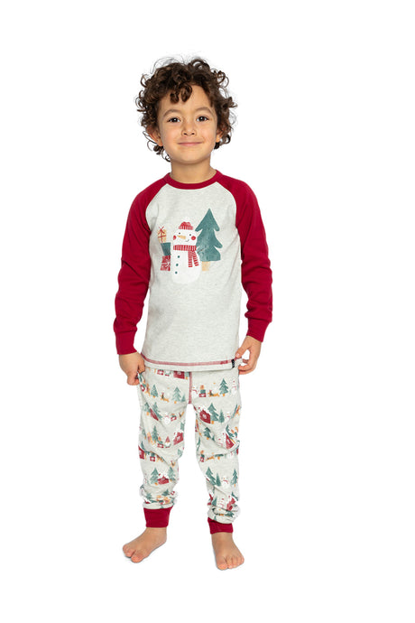 Child wearing the beige Christmas pajama set standing and smiling