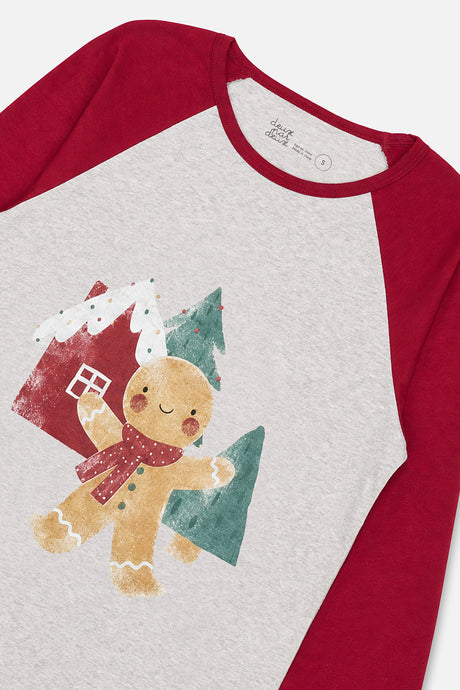 Close-up of the gingerbread character and house graphic and red raglan sleeve on the grey pajama top
