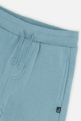 Close-up of the ribbed waistband, drawstring and side pocket on the pale turquoise sweatpants