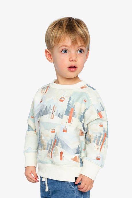 Child wearing the beige ski print fleece sweatshirt, angled front view