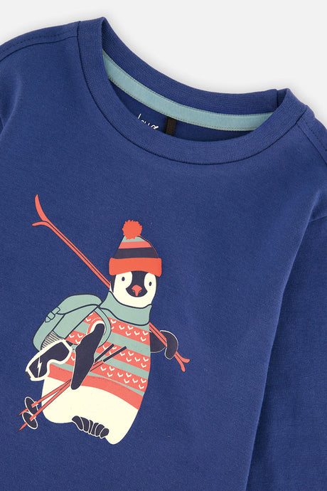 Close-up of the skiing penguin graphic and crew neckline with light blue trim on the blue tee