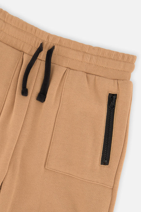 Close-up of the drawstring waistband and zippered pocket on the brown tannin sweatpants