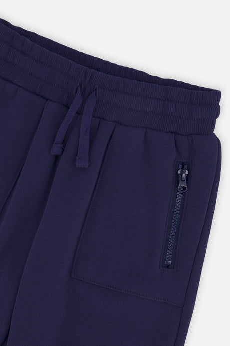 Close-up of the drawstring waistband and zippered pocket on the dark blue sweatpants