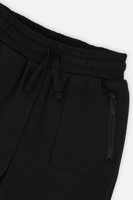 Close-up of the drawstring waistband and zippered pocket on the black sweatpants
