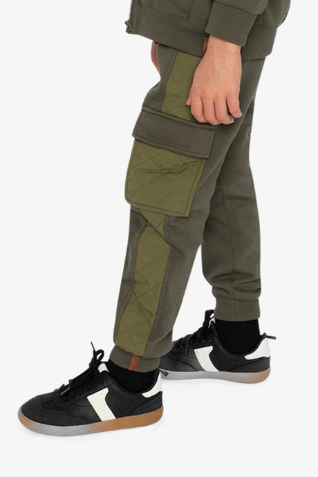 Child wearing the green cargo sweatpants, side view of the flapped cargo pocket and quilted panel