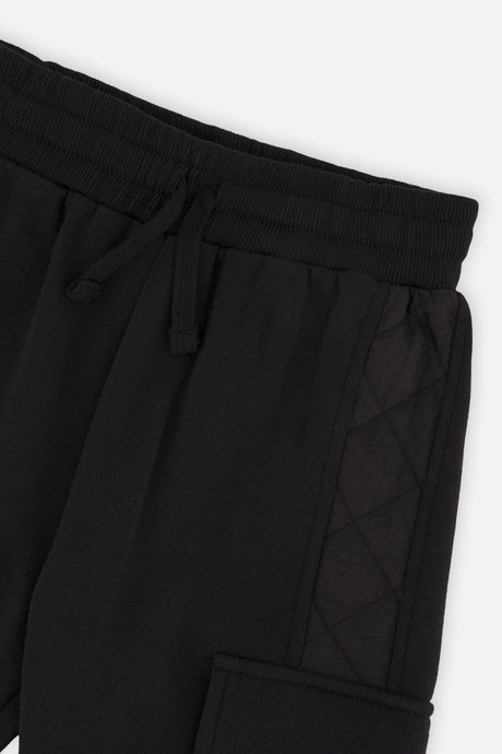Close-up of the drawstring waistband and quilted side panel on the black cargo sweatpants