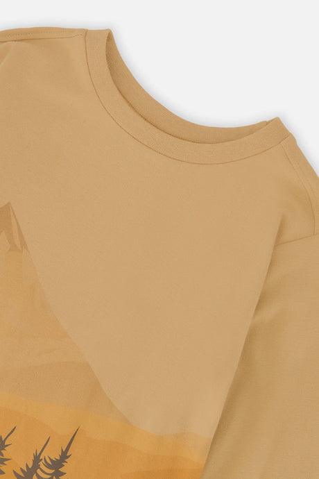 Close-up of the crew neckline and mountain graphic on the beige tee