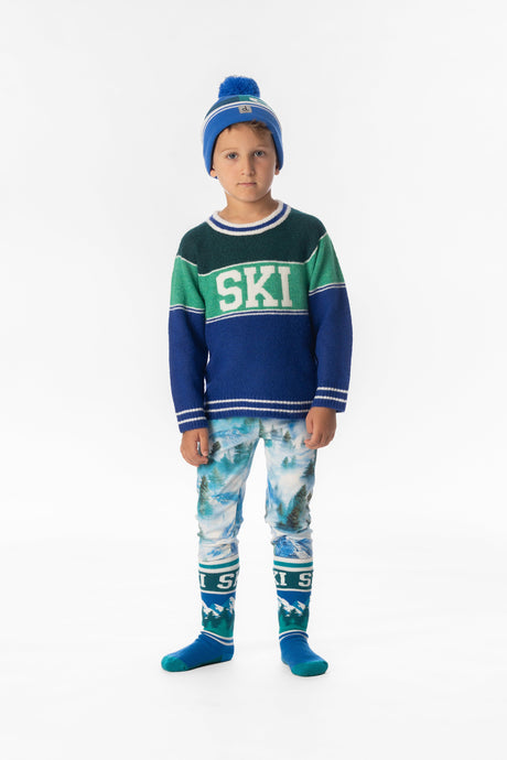Child wearing the Deux par Deux SKI colorblock sweater with a blue pom-pom hat, front view