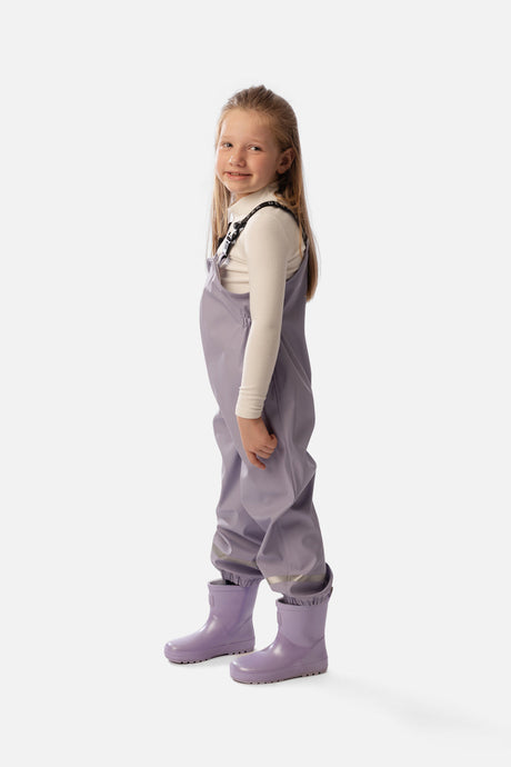 Child wearing the Deux par Deux mauve rain overalls, side view