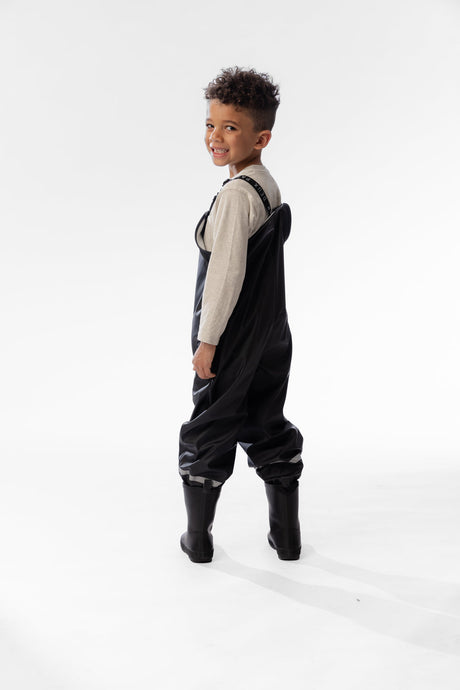 Child in the Deux par Deux black waterproof rain overalls, lifestyle photo