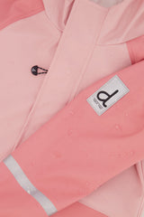 Close-up of the Deux par Deux label and reflective band on the pink rain jacket sleeve