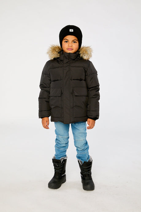Child wearing the Deux par Deux black winter jacket with faux-fur hood, view 1