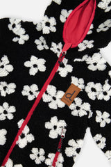 Close-up of the white flowers on the black sherpa, the pink zipper and the brand label