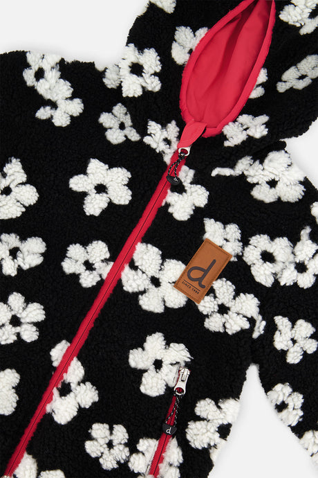 Close-up of the white flowers on the black sherpa, the pink zipper and the brand label