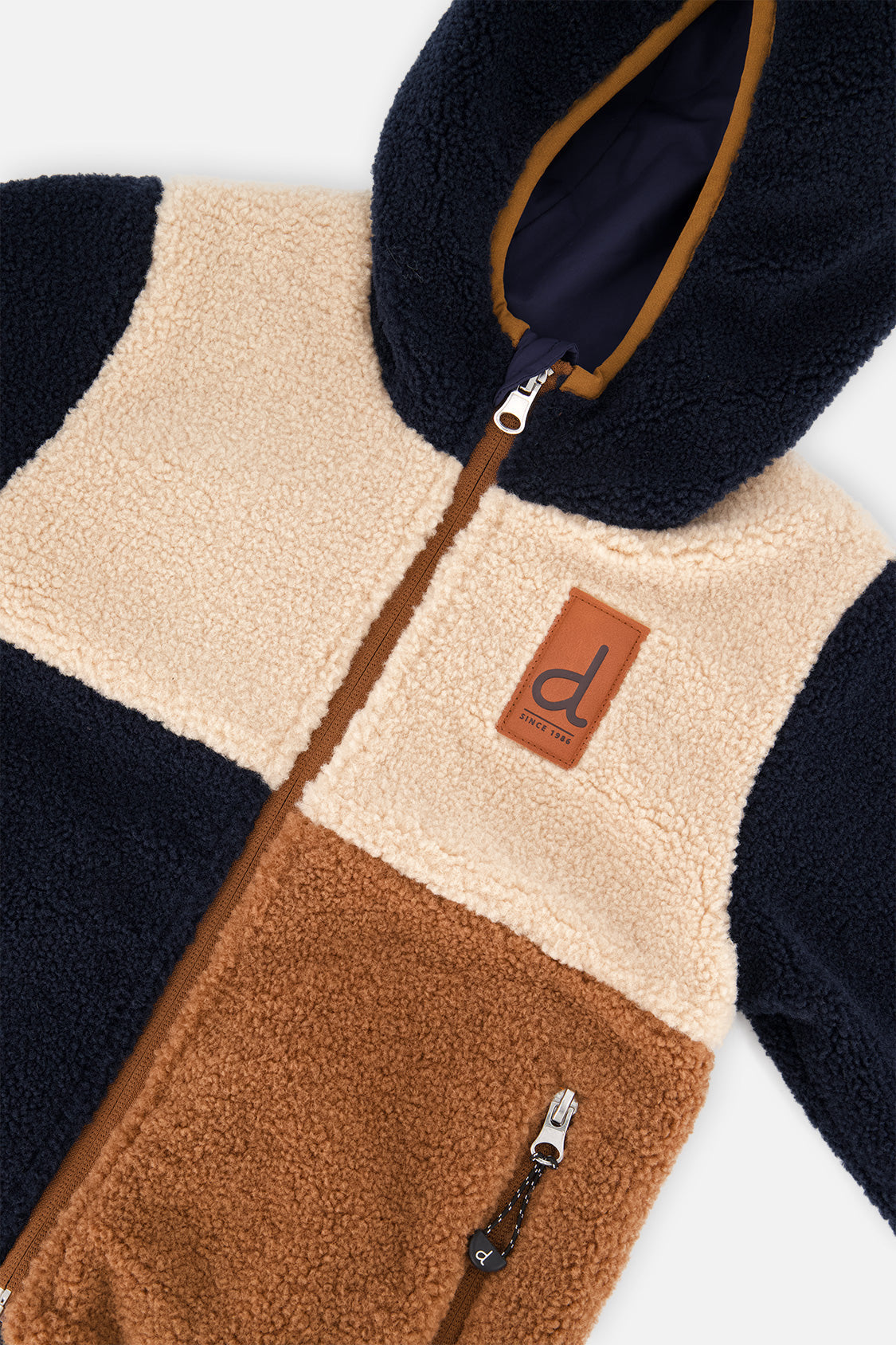 Close-up of the beige and brown sherpa blocks and front zipper on the reversible jacket
