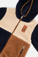 Close-up of the beige and brown sherpa blocks and front zipper on the reversible jacket