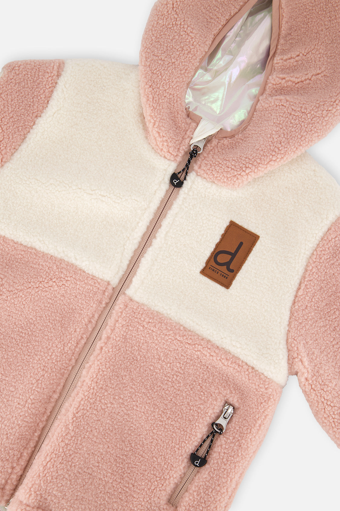Close-up of the pink and cream sherpa, zipper and brand label