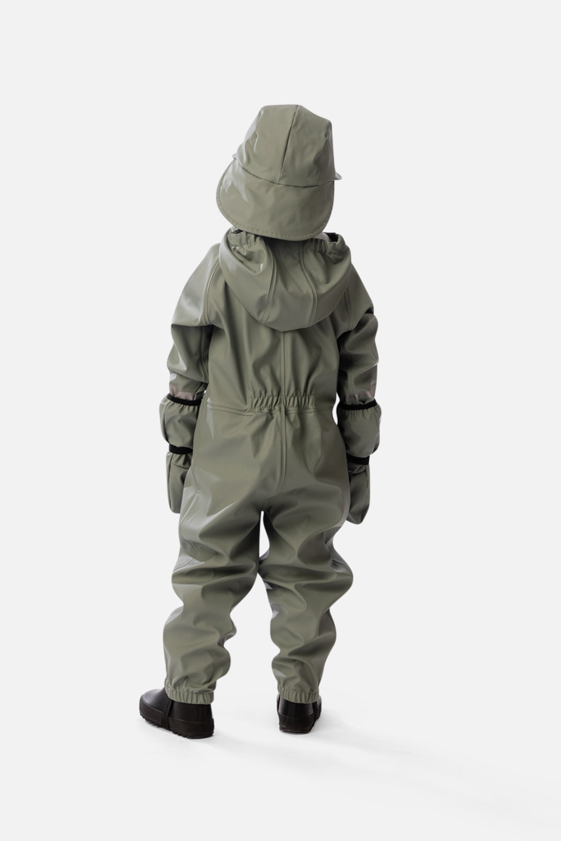 Lifestyle photo of a child wearing the Deux par Deux sage green colorblock rain one-piece