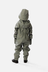 Lifestyle photo of a child wearing the Deux par Deux sage green colorblock rain one-piece