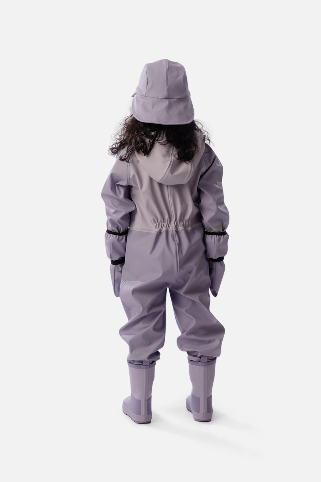Back view of a child wearing the mauve rain one-piece with a mauve rain hat and rain boots