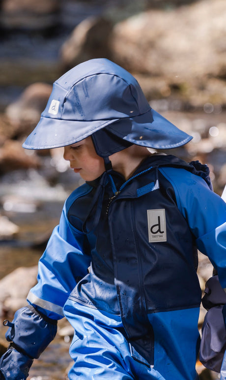 Child wearing the Deux par Deux dark blue rain bucket hat outdoors