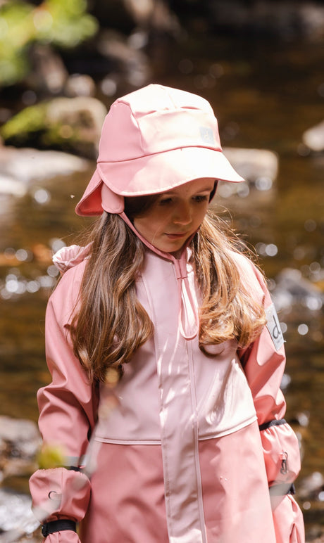 Child wearing the Deux par Deux pink rain bucket hat outdoors