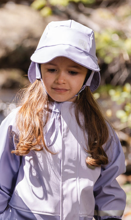 Child wearing the Deux par Deux mauve rain bucket hat outdoors