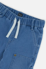 Close-up of the elastic waist, drawcord and cargo pocket on baby light blue French terry denim-look pants