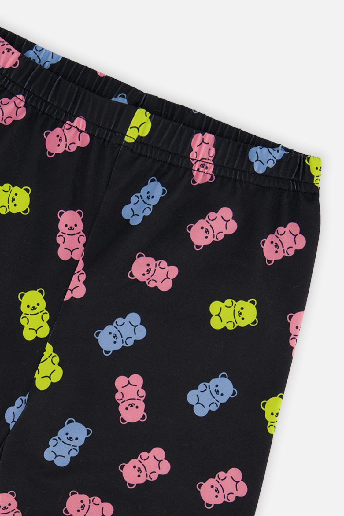Close-up of the elastic waistband and pink, blue and lime gummy bears on the black leggings