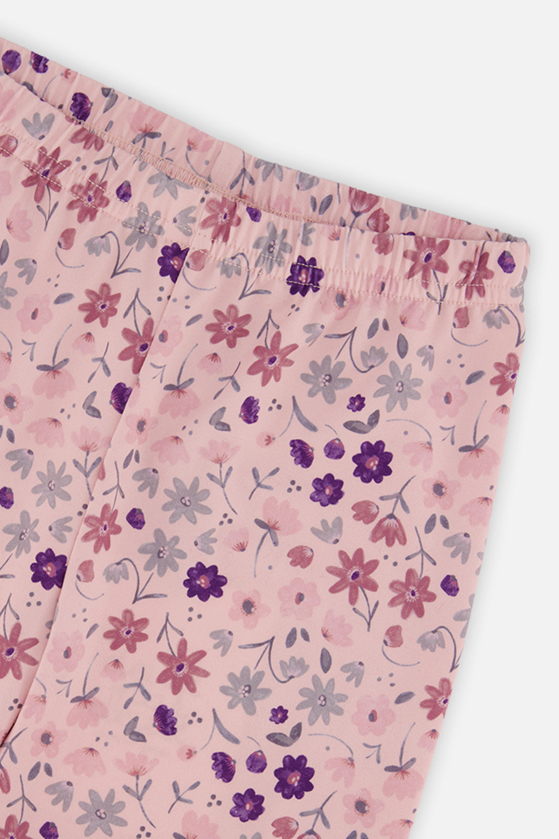 Close-up of the elastic waistband and purple and pink daisy print on the leggings