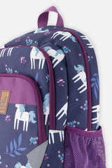 Closeup of Blue unicorn backpack with compartments, side pocket, and colorful printed details.