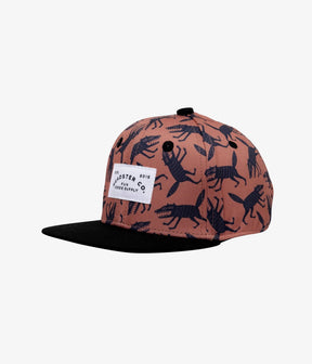 Amber Chupacabra kids snapback with navy creature print and black brim, angled front view