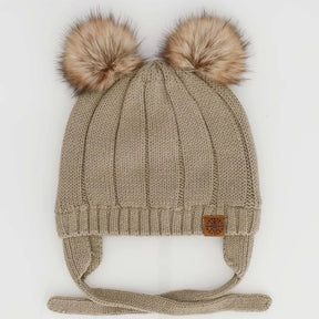 Cashmere-tone knit CALIKIDS baby hat with two tan faux-fur pompoms, ear coverage and chin ties