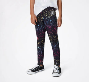 Child wearing black Converse high-rise leggings with a multicolor splatter print, front view