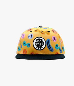 Front view of yellow Peppy snapback with round Headster patch and black flat brim