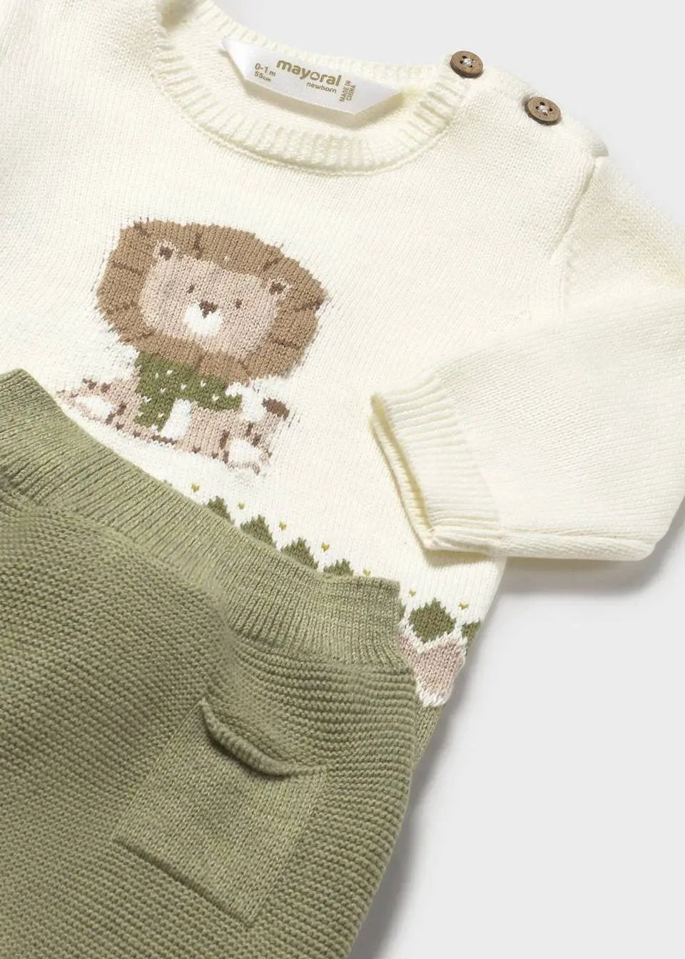 Closeup of jacquard motif and shoulder buttons on knit sweatshirt.