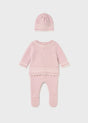 Full view of three-piece knit set for newborn girls with bow hat and footed pants.