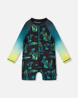 Front flat lay of Deux par Deux boy long sleeve one-piece swimsuit in black surf print with gradient sleeves