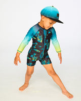 Boy posing in studio in black surf long sleeve rashguard romper front view