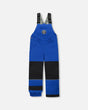 Flat lay of boys Solid Blue snow bib overall with reinforced knees.
