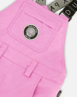 Closeup of bib chest pocket and strap hardware on waterproof, breathable fabric.